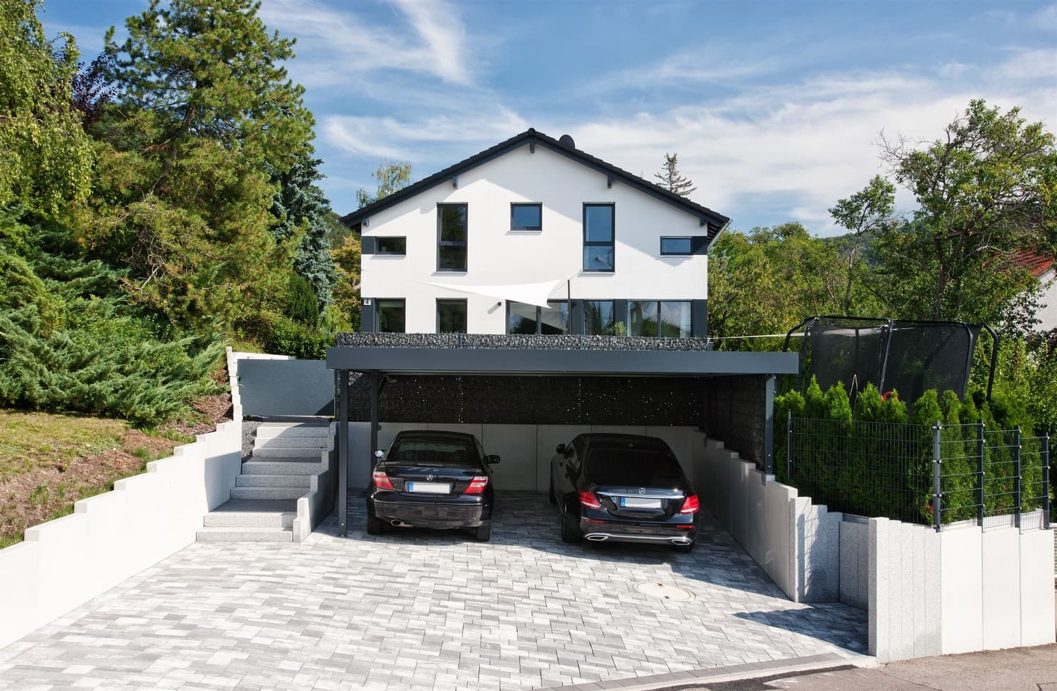 Modernes Wohnhaus mit Garage und gepflasterter Zufahrt — entstanden aus einer Wohnbaufläche