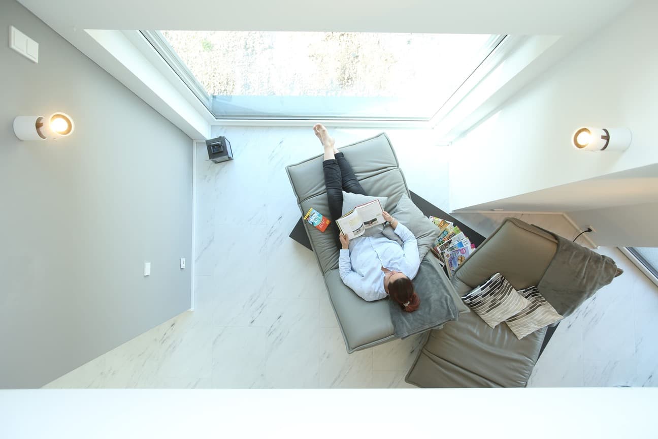 Person beim Lesen in einem hellen, modernen Wohnraum