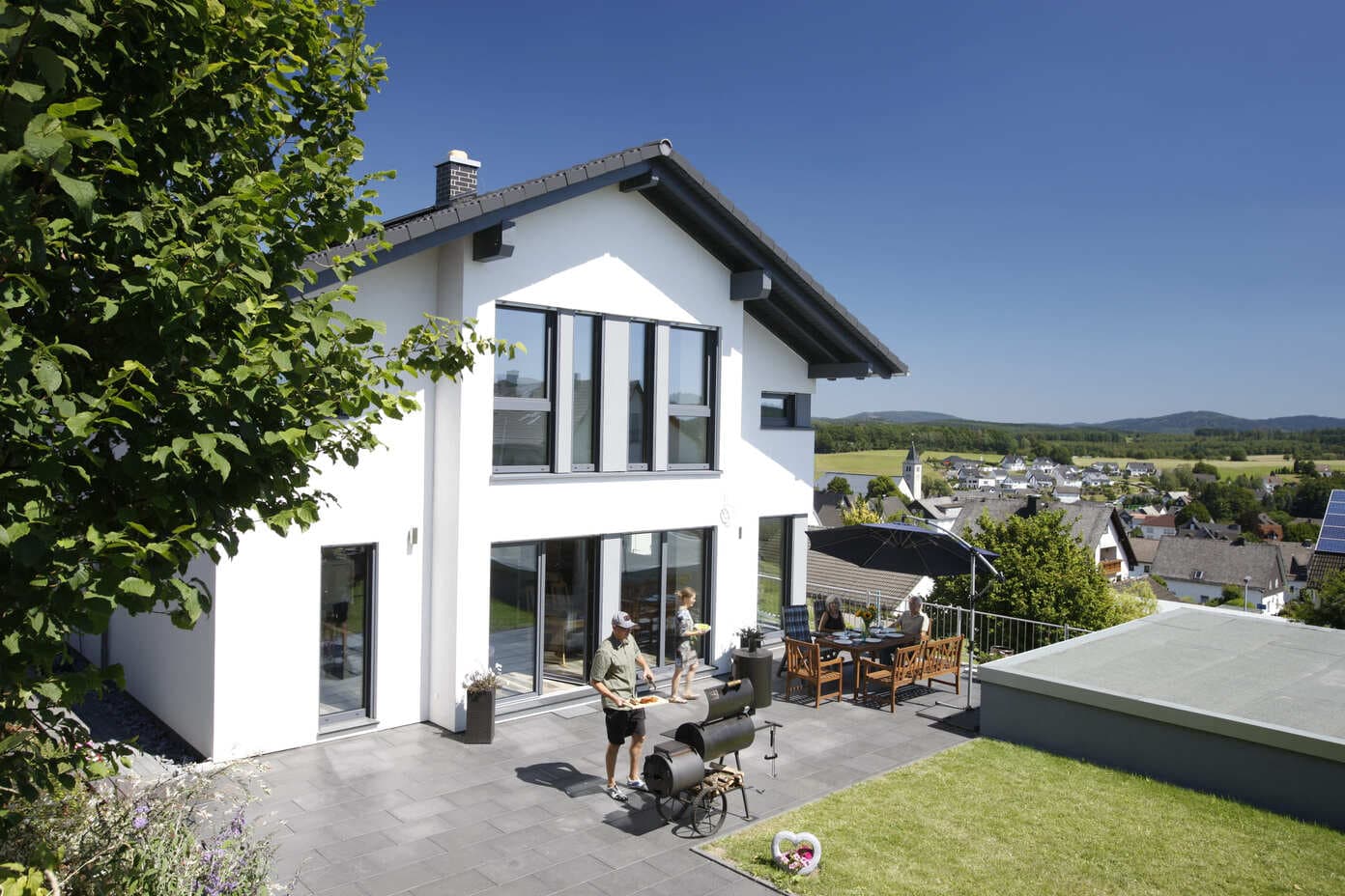 Familien auf der Terrasse eines geförderten Sozialquartier-Hauses an einem sonnigen Tag